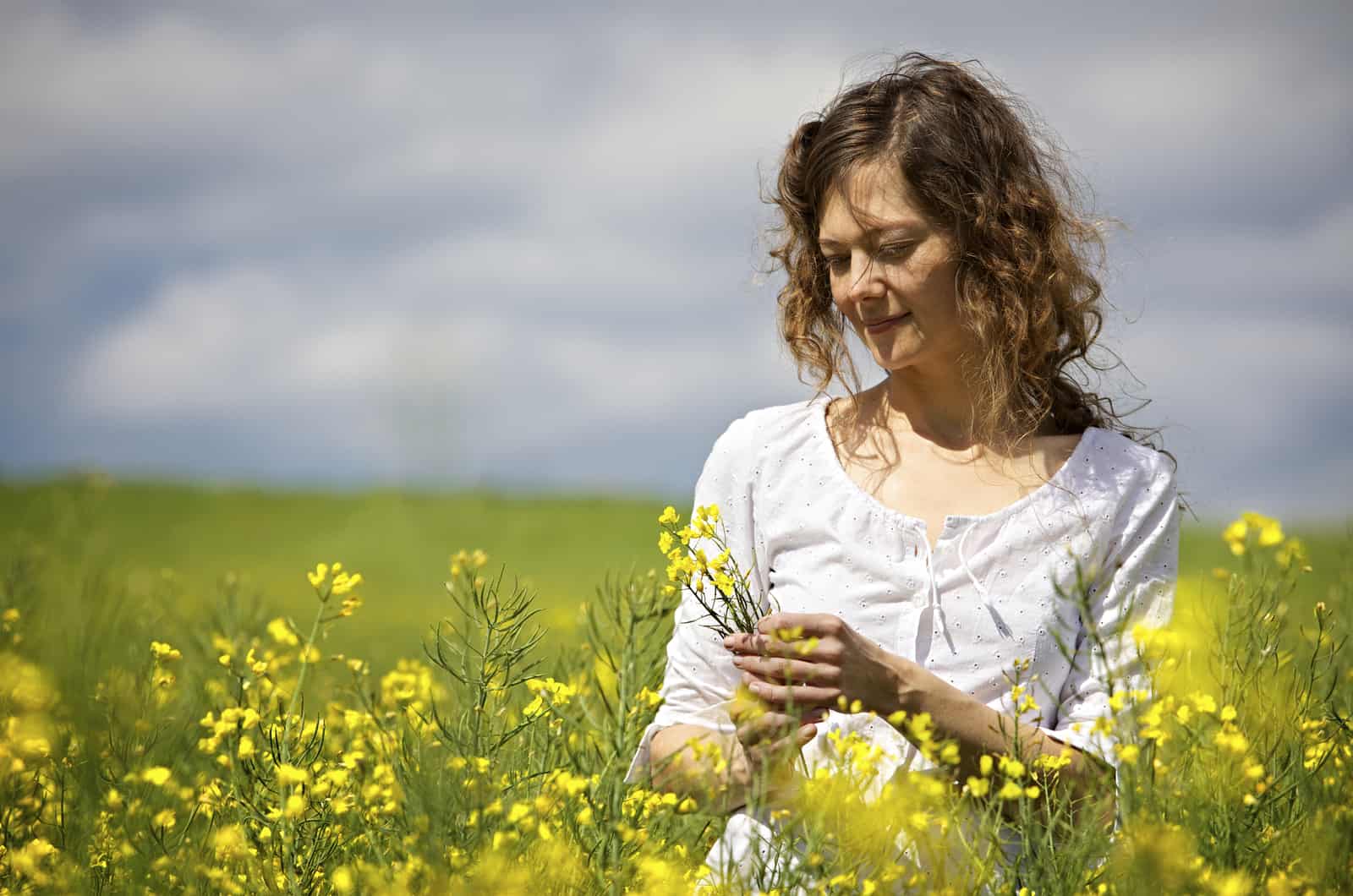 woman standing in field of flowers