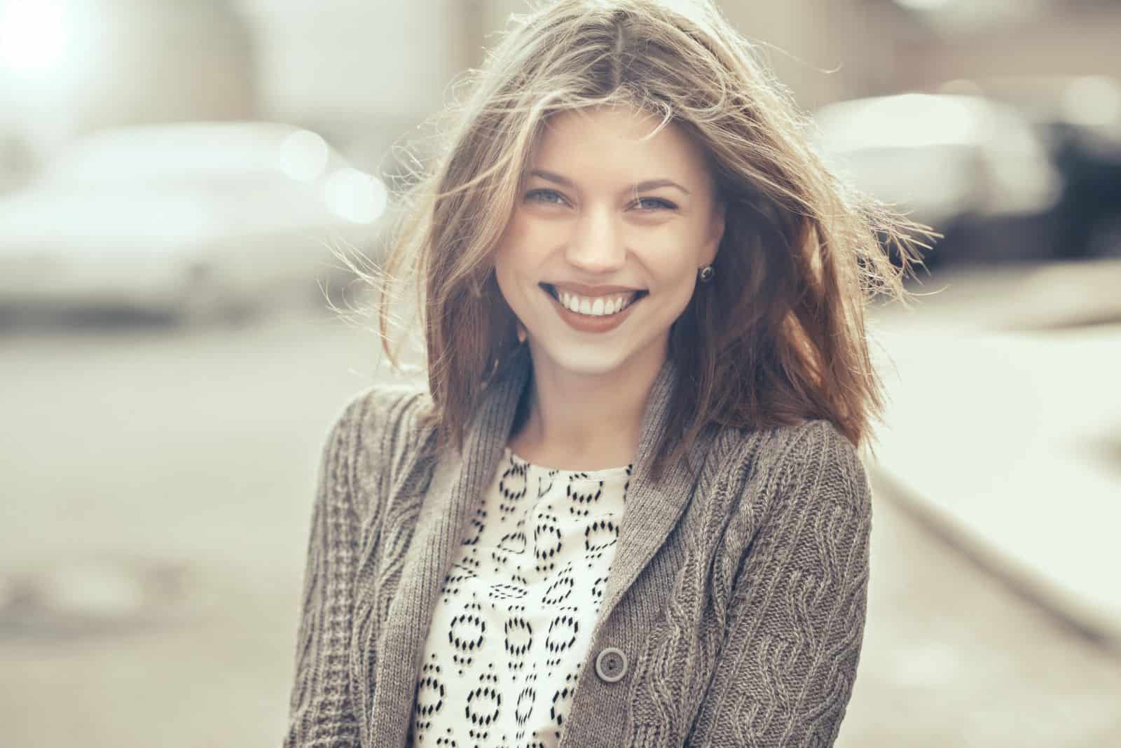 a cute girl is standing on the street