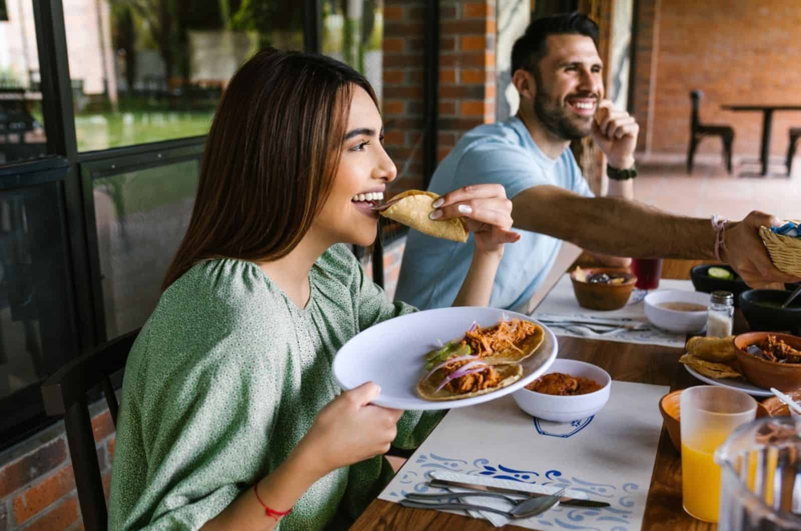 young latin woman eating mexican taco