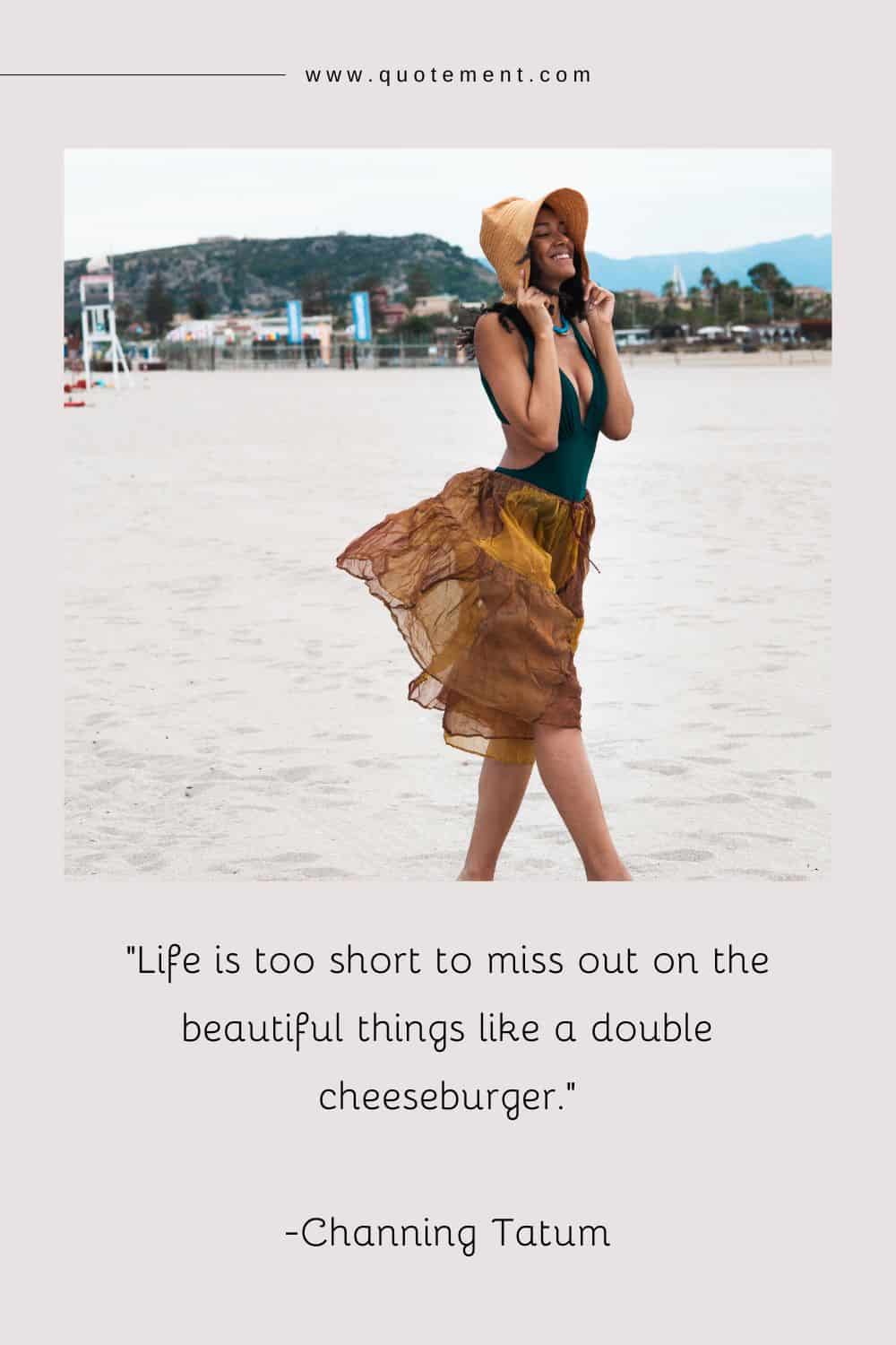 a girl on the beach smiles as she keeps her hat in place