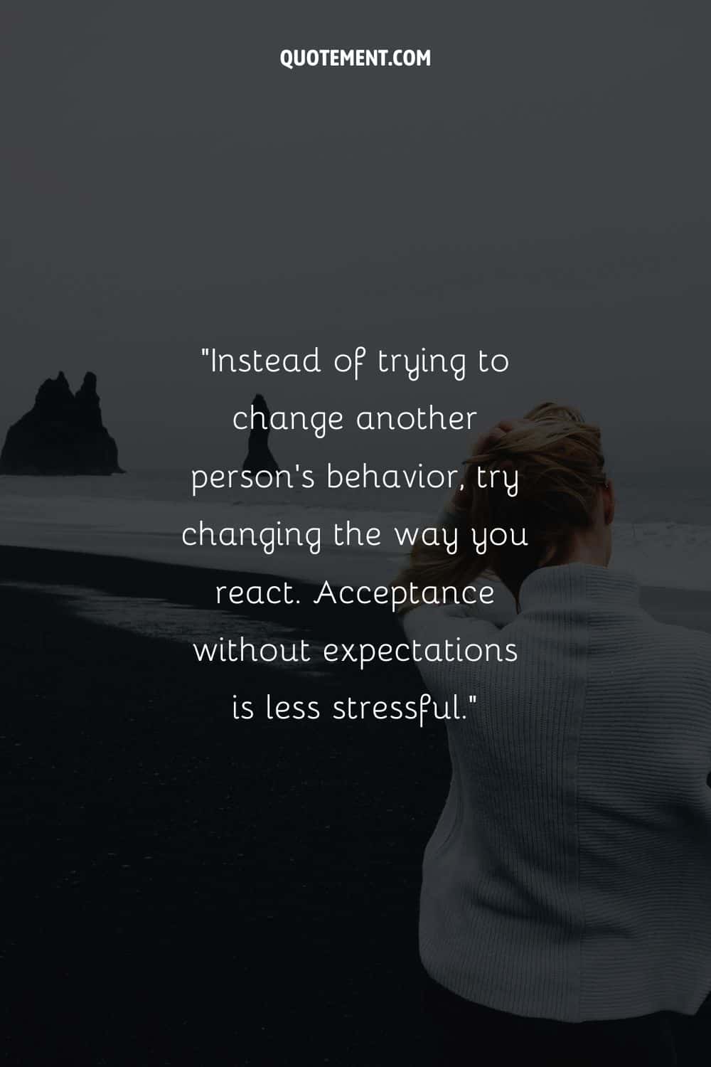 Woman at the beach in cozy white sweater representing a quote on acceptance.