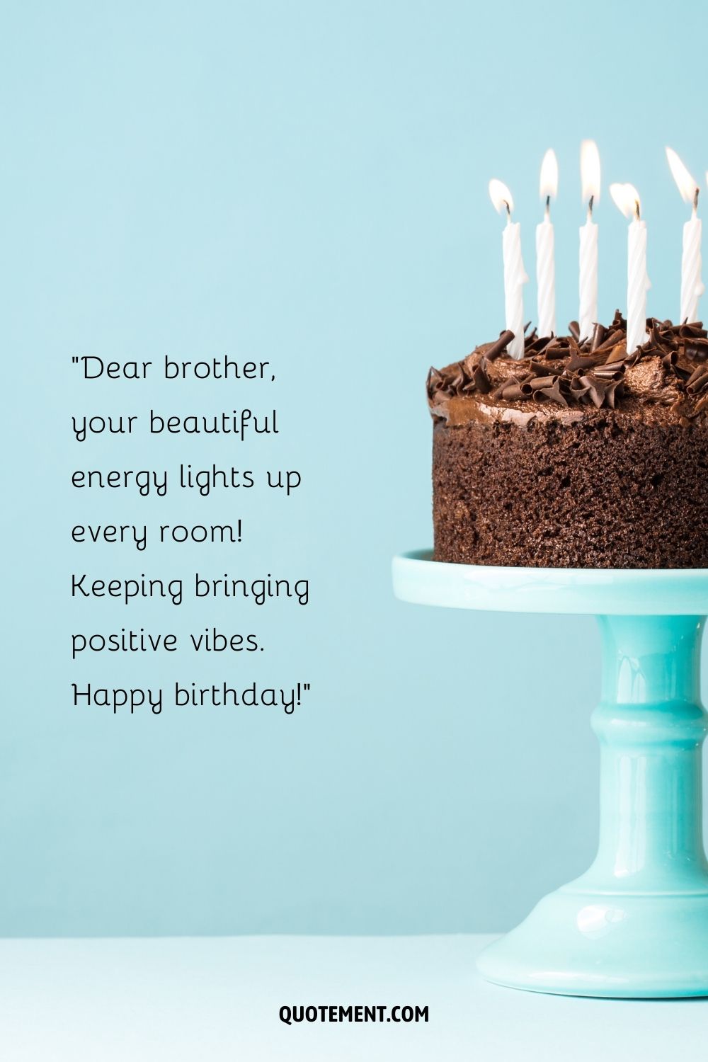 chocolate birthday cake presented on a blue cake stand against a matching blue backdrop
