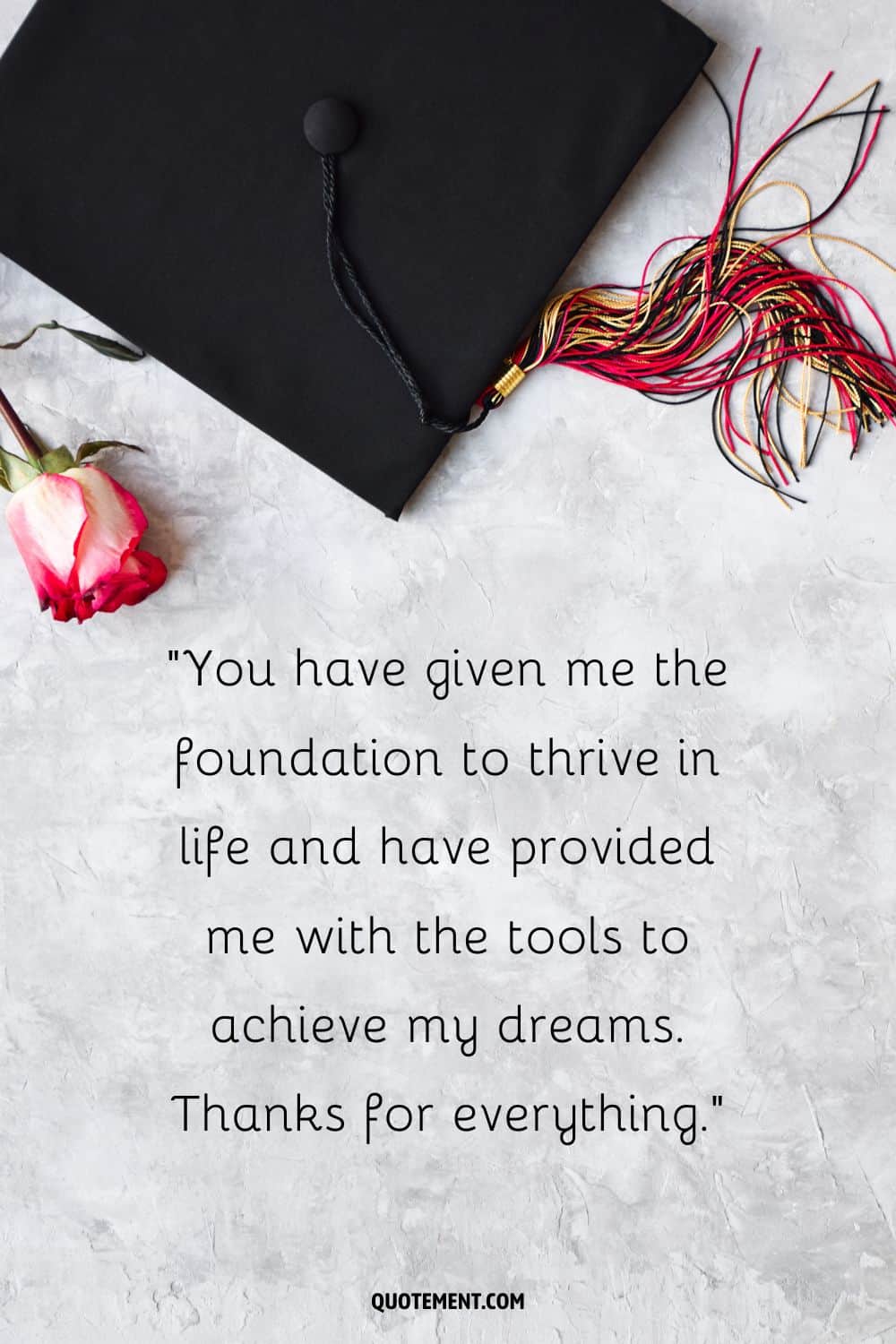 graduate cap and a rose on a white surface