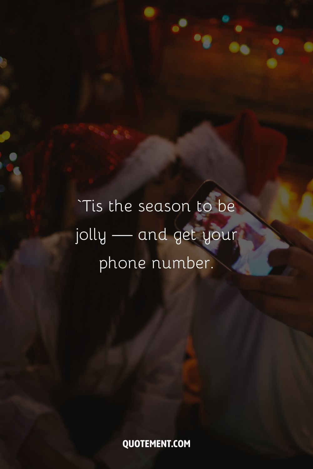 A smiling couple wearing Santa hats are about to kiss as someone takes a picture of them