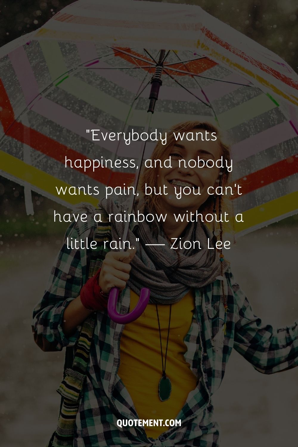 A cheerful blonde woman with an umbrella standing out against the rainy backdrop
