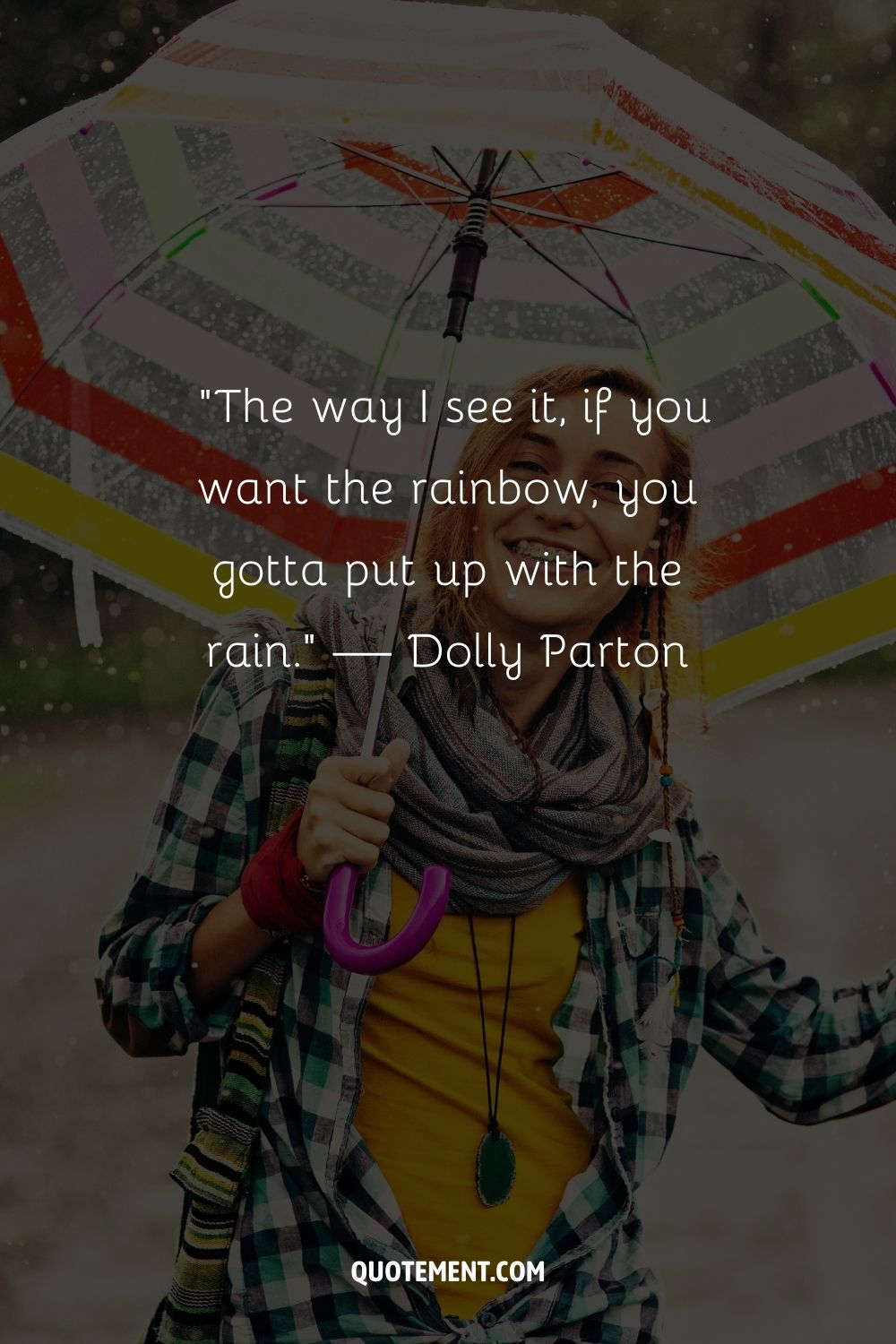 A smiling woman holding a colorful umbrella during a rain shower
