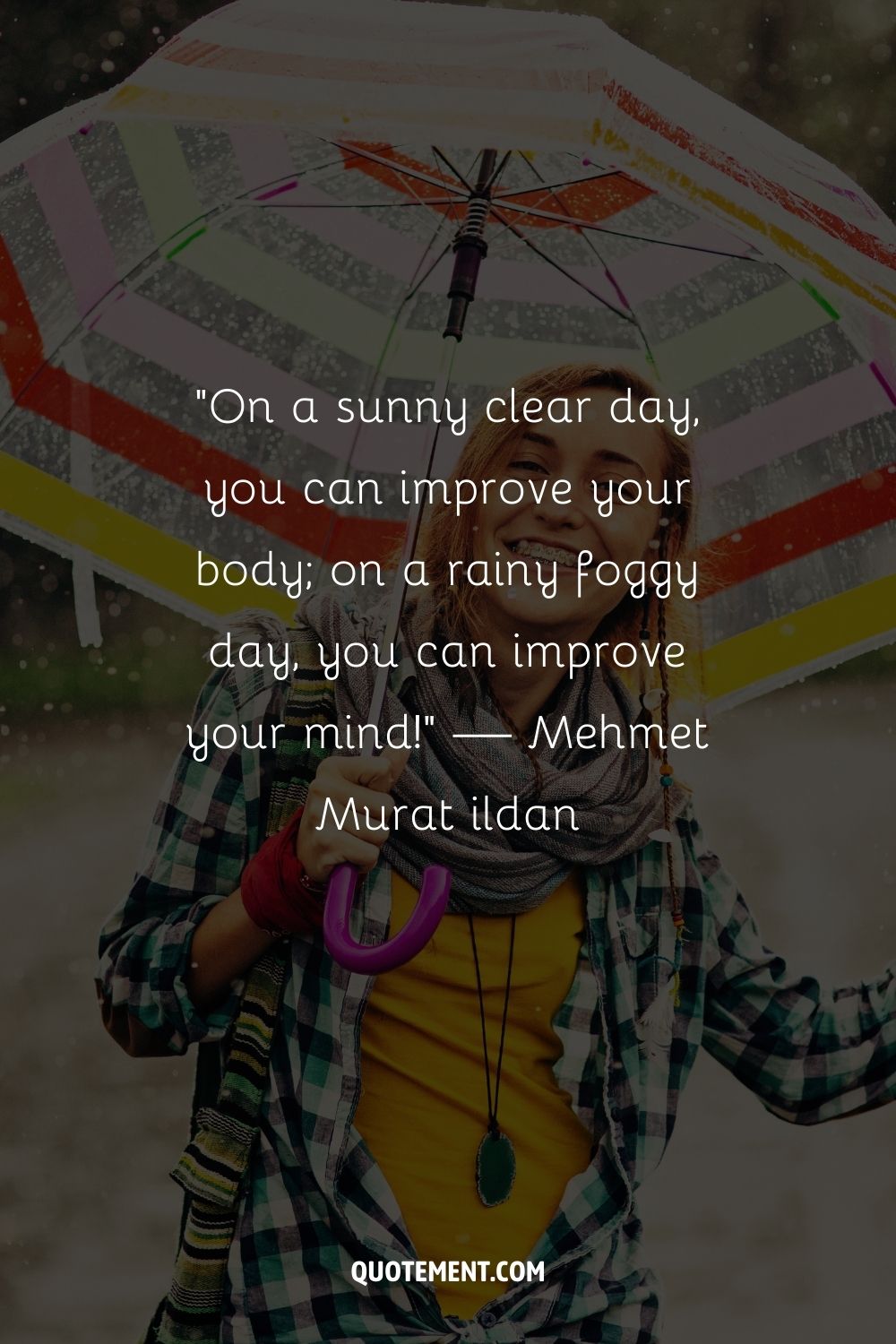 A woman in a checkered shirt and yellow dress enjoys the rain under an umbrella
