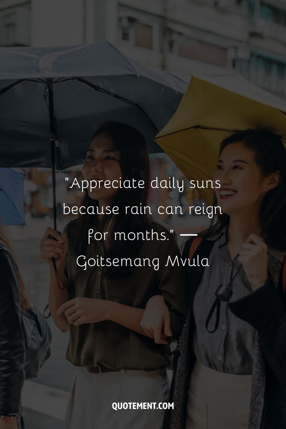 Two cheerful women using umbrellas on rainy day
